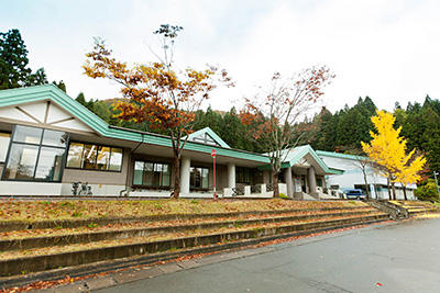 薄緑色の屋根と白い壁をした、一階建ての宿泊施設の写真